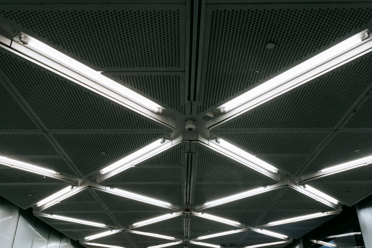 From below of glowing LED lamps on ventilated ceiling in underground parking of modern building